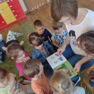 Dzieci słuchają bajki czytanej przez rodzica.
