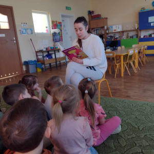 Dzieci słuchają bajki czytanej przez rodzica.