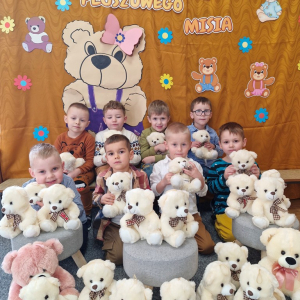 Chłopcy wśród misiów na tle dekoracji związanej z Dniem Pluszowego Misia