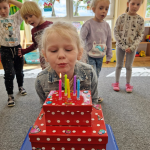 Maja zdmuchuje świeczki na torcie
