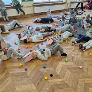 Dzieci leżąc na plecach, oddychają z kaczuszką na brzuchu