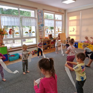 Dzieci  naśladując wiatr zrywają "pajęczynę
