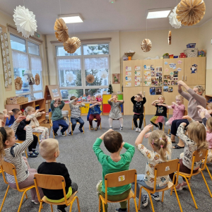 Dzieci przedstawiają utwór muzyczny Country Dance prostymi elementami ruchu