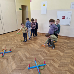 Chłopcy rzucają krążki na krzyżaki