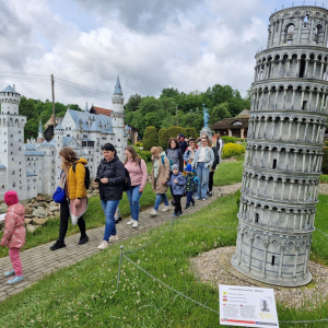 Rodzice i dzieci ogladają miniaturowe budowle, np.  Krzywą Wieżę w Pizie