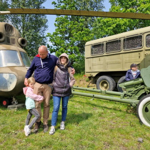 Rodzice  z dziećmi na tle zabytkowych pojazdów wojskowych