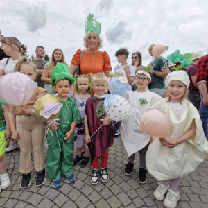 „Nasza warzywna drużyna z wiersza 'Na straganie' maszeruje przez miasto z balonami z cytatami Brzechwy.”