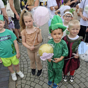 „Nasza warzywna drużyna z wiersza 'Na straganie' maszeruje przez miasto z balonami z cytatami Brzechwy.”