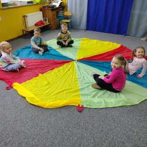 Dzieci siedzące na chuście animacyjnej.