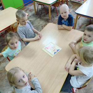 Dzieci siedzące przy stoliku.