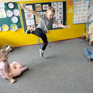 Chłopiec przeskakujący przez skakankę.