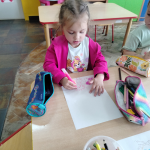 Dziewczynka rysująca superbohatera.