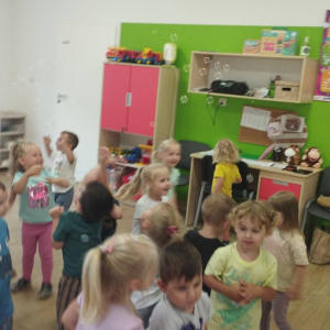 Dzieci łapią bańki mydlane z p. Asią i p. Dorotką.