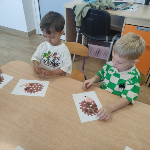 Dzieci wyklejają szablon jeża plasteliną