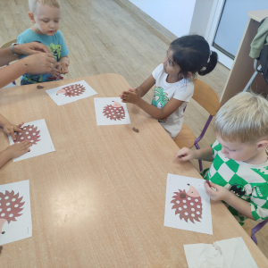 Dzieci wyklejają szablon jeża plasteliną