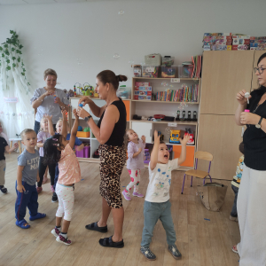 Dzieci wraz z paniami puszczają bańki mydlane w sali