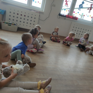 Dzieci siedzą w kole na zajęciach