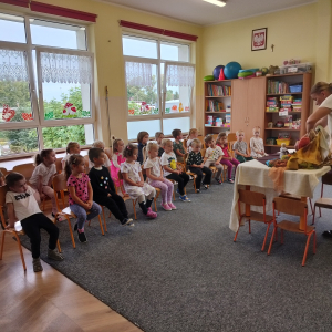 Dzieci siedzące na krzesełkach.