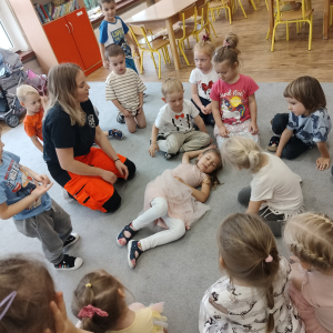 Dzieci siedzące na dywanie.