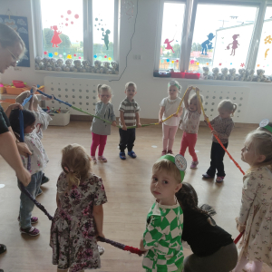 Dzieci stojące w kole i bawiące się gumą sensoryczną