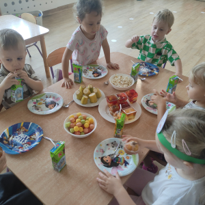 Dzieci siedzące przy stoliku podczas słodkiego poczęstunku