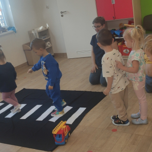 Dzieci podczas nauki prawidłowego przejścia przez pasy.