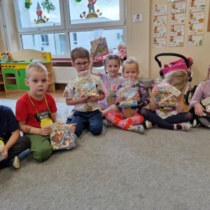 Dzieci z upominkami-książeczką i ołówkiem