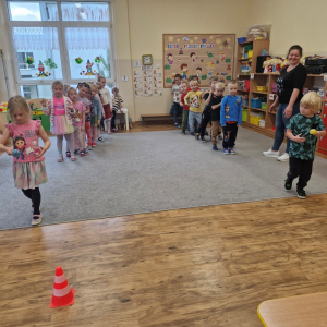 Dzieci niosą na łyżce małą piłeczkę