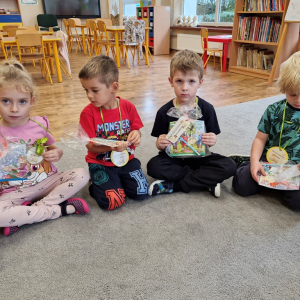 Dzieci z upominkami-książeczką i ołówkiem