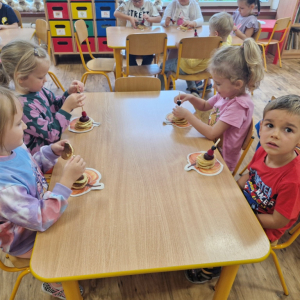 Dzieci w czasie konsumpcji pankejek  owocami