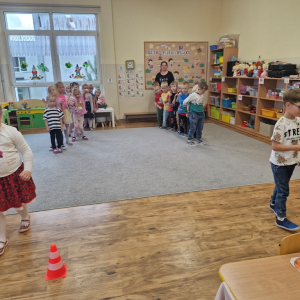 Dzieci niosą na łyżce małą piłeczkę