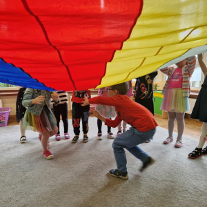 Dzieci przebiegają pod chustą animacyjną