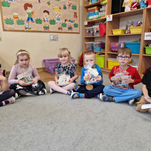 Dzieci z upominkami-książeczką i ołówkiem