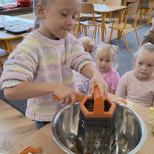 dziewczynka podczas tarcia marchewki