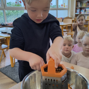 chłopiec podczas tarcia marchewki