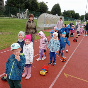 dzieci z grupy Biedronki podczas przemarszu z autkami na sznurku