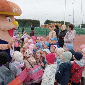 dzieci z grupy Biedronki podczas przemarszu z autkami na sznurku