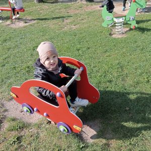 chłopiec na bujaku w kształcie autka