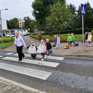 Dzieci z Panią Marysią przechodzą po pasach na drugą stronę