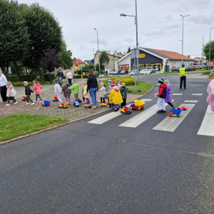 Dzieci pod opieką wychowawczyń przechodzą po pasach na druga stronę jezdni
