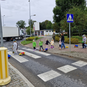 Dzieci z Panią  Magdą przechodzą po pasach na druga stronę
