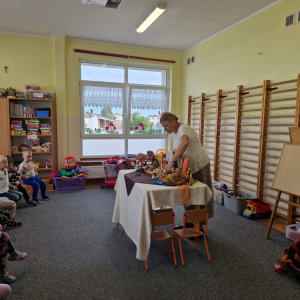 Pani Kasia Bajeczka opowiada  bajeczkę, poruszając figurkami postaci