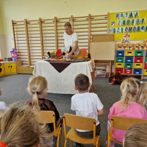 Pani Kasia Bajeczka opowiada  bajeczkę,  poruszając figurkami postaci