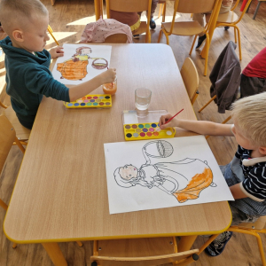 Chłopcy w czasie malowania  obrazka Pani Jesieni farbami akwarelowymi