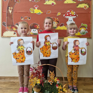 Dziewczynki  z obrazkami Pani Jesieni na tle dekoracji jesiennej 