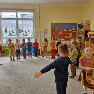 Dzieczynka w roli pani Jesieni chodzi slalomem wokół dzieci