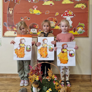 Dziewczynki  z obrazkami Pani Jesieni na tle dekoracji jesiennej    