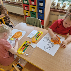 Dziewczynki w czasie malowania obrazka Pani Jesieni farbami akwarelowymi