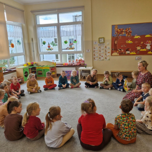 Dzieci siedząc  w kole, słuchają piosenki o jesieni