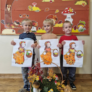 Chłopcy z obrazkami Pani Jesieni na tle dekoracji jesiennej 